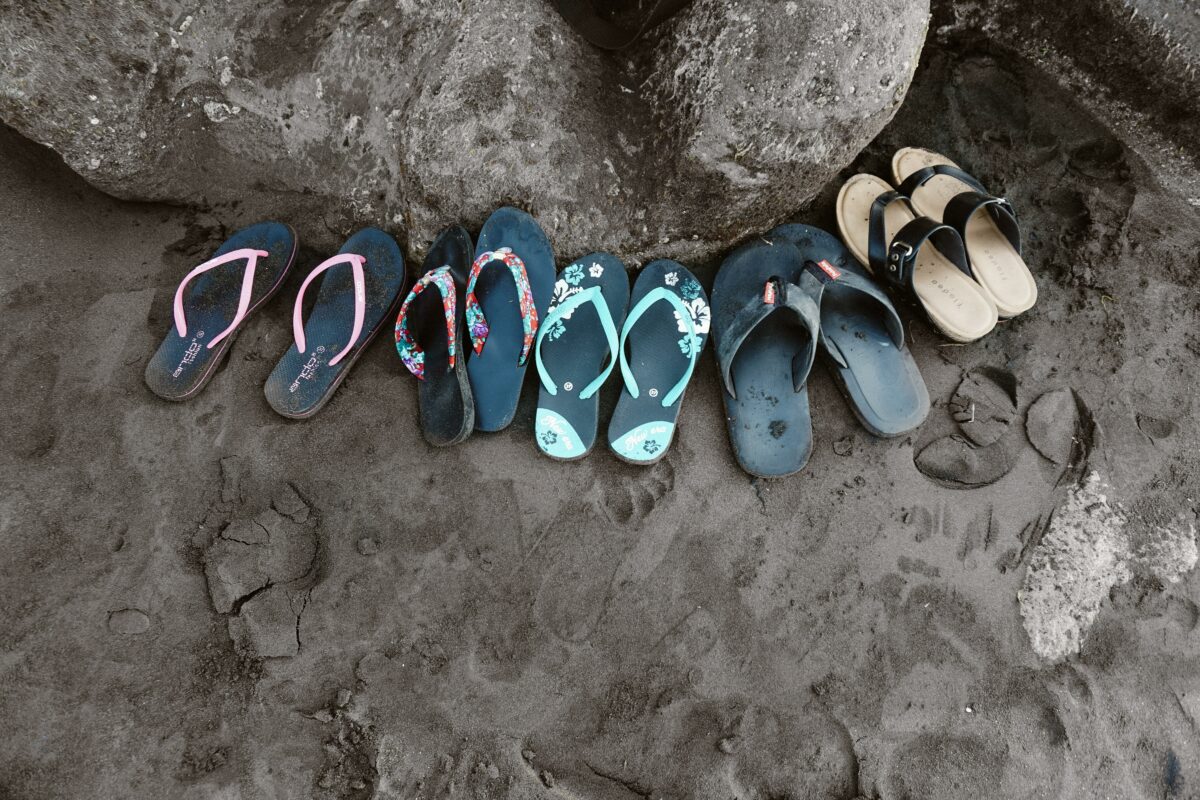Assorted flip flops on sand 952843